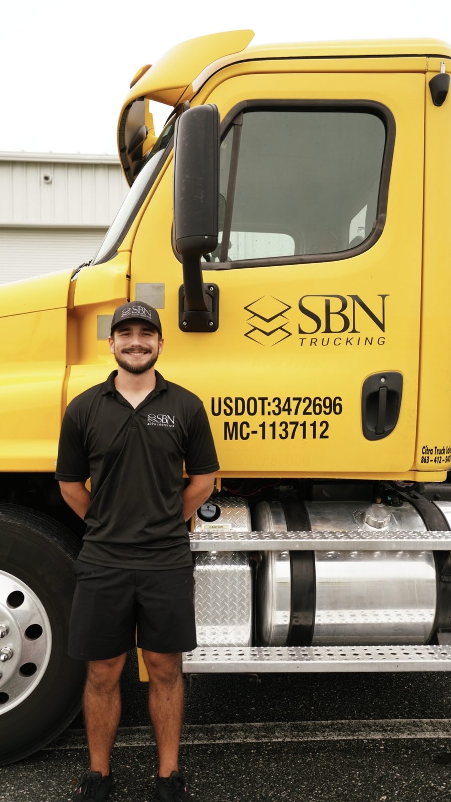 Hayden from SBN Auto Logistics standing beside an SBN truck